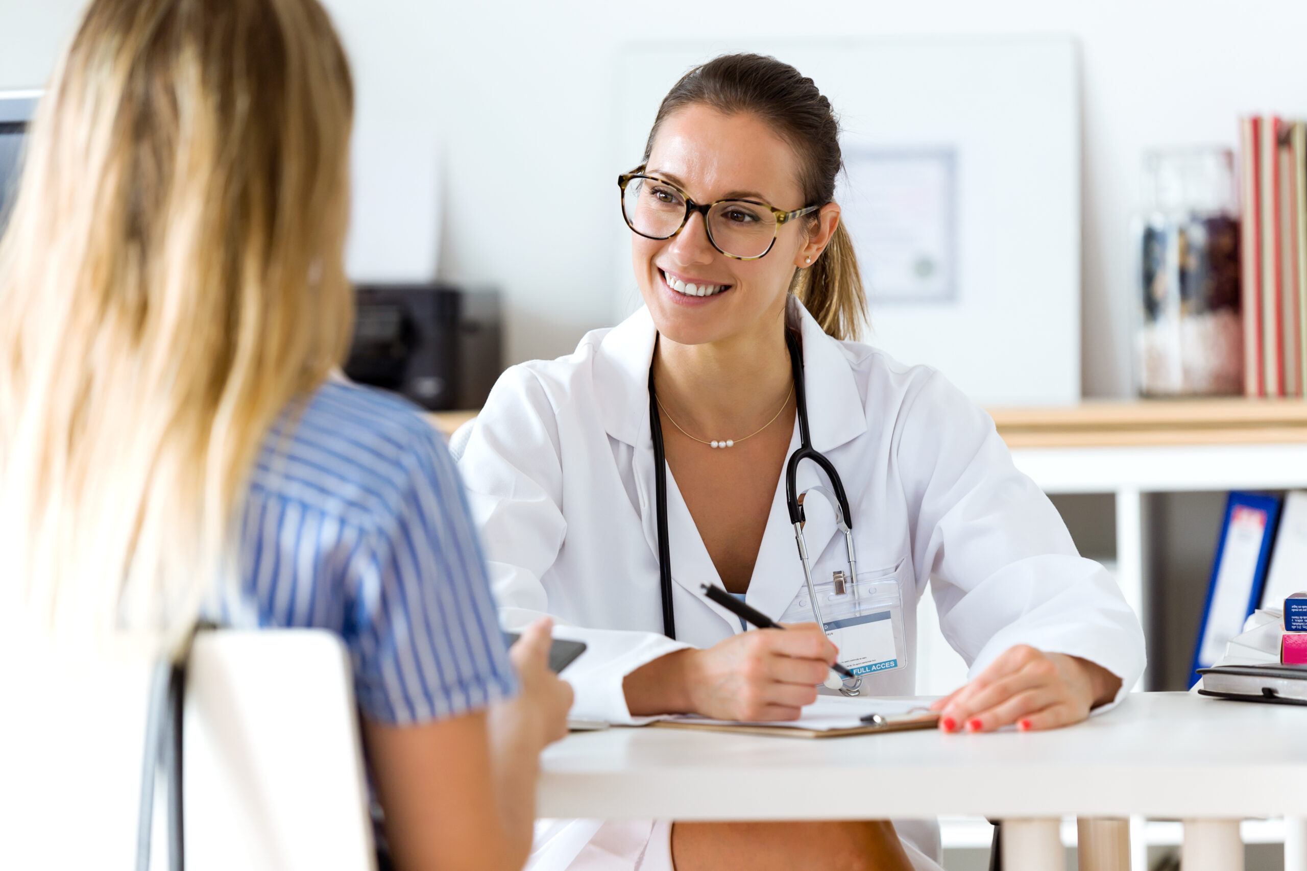 Eine Ärztin spricht lächelnd mit einer Patientin.