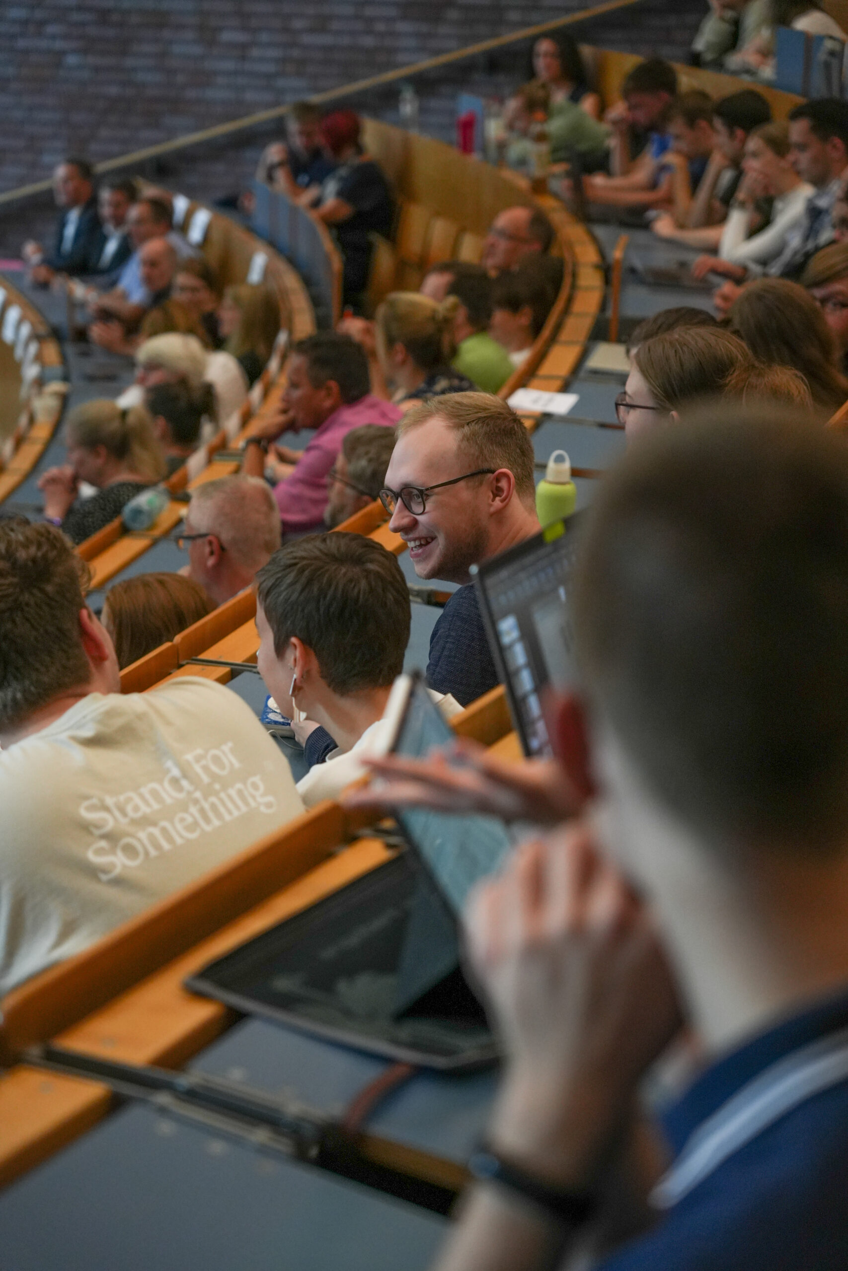 Viele Leute in einem großen Vorlesungssaal.